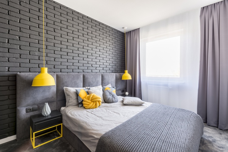 Udobna spavaća soba sa sivim akcentnim zidom i žutim akcentima